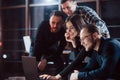 Cheerful people. Team of young business people works on their project at night time in the office