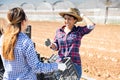 Cheerful Peruvian woman farmer talking to young workwoman