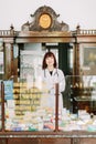 Cheerful pharmacist chemist woman standing in trading hall in vintage pharmacy drugstore Royalty Free Stock Photo
