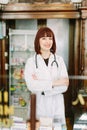 Cheerful pharmacist chemist woman standing in trading hall in vintage pharmacy drugstore Royalty Free Stock Photo