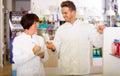 Pharmacist and pharmacy technician posing in drugstore Royalty Free Stock Photo