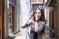 Cheerful photographer woman with sunglasses holding camera taking photo in city. Traveler young girl use digital camera take Royalty Free Stock Photo