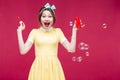 Cheerful pinup girl laughing and having fun with soap bubbles Royalty Free Stock Photo