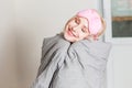 Positive woman with pillow sitting in bed and smiling to camera at home Royalty Free Stock Photo