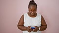 Cheerful plus-size african american woman, sporting stylish braids and glasses, enthusiastically using her smartphone, joyfully