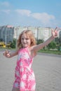 Cheerful portrait of a little five year old girl in a pink summer dress on the streets of her city Royalty Free Stock Photo