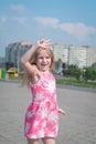 Cheerful portrait of a little five year old girl in a pink summer dress on the streets of her city Royalty Free Stock Photo