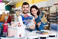 Couple purchasing tools for house improvements in paint supplies store Royalty Free Stock Photo