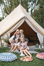 Cheerful positive family of four, mother, father and two daughters, having a picnic and eating watermelon outdoors in a Royalty Free Stock Photo