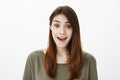 Cheerful positive girl saying wow hearing pleasant news. Portrait of good-looking carefree girlfriend in dark-green t Royalty Free Stock Photo