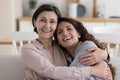 Cheerful positive mature 50s mom hugging adult daughter woman Royalty Free Stock Photo