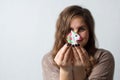 Cheerful positive woman holds a toy unicorn near her forehead