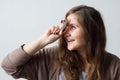 Cheerful positive woman holds a toy unicorn near her forehead