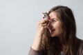 Cheerful positive woman holds a toy unicorn near her forehead