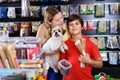 Cheerful woman with preteen son buying dog treats and chews in store to reward their precious pup Royalty Free Stock Photo