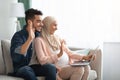 Cheerful Pregnant Muslim Couple Using Laptop At Home For Video Call Royalty Free Stock Photo