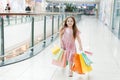 Cheerful preschool girl walking with shopping bags. Pretty smiling little girl with shopping bags posing in the shop. The concept