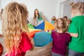 Teacher and kindergarten kids playing with colorful parachute Royalty Free Stock Photo