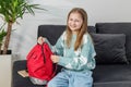 Morning preparation before school. Smiling Girl with Red Backpack on Couch. Back to school Royalty Free Stock Photo