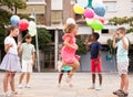 Cheerful preteen children with balloons playing chinese jump rope outdoors Royalty Free Stock Photo