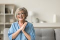 Cheerful pretty older woman in elegant glasses sitting on couch Royalty Free Stock Photo