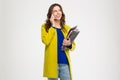 Cheerful pretty woman holding folders and talking on cellphone Royalty Free Stock Photo