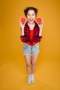 Cheerful pretty young woman holding two halves of grapefruit