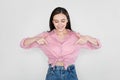 Cheerful pretty young woman pointing down, grey background