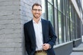 cheerful professional businessman posing near office