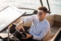 Aspirational successful businessman standing by luxury boats and yachts against a deep blue sky, holding his jacket over Royalty Free Stock Photo