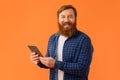 Cheerful redhaired bearded man in casual holding digital tablet, studio Royalty Free Stock Photo