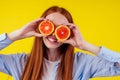 Cheerful, redhaired ginger woman holding red orenge in studio yellow background,autumn vitamin immunity concept