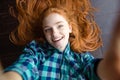 Cheerful redhead woman making self image lying on the floor Royalty Free Stock Photo