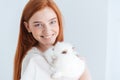 Cheerful redhead woman posing with rabbit