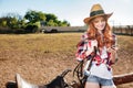 Cheerful redhead young woman cowgirl using cell phone in village Royalty Free Stock Photo