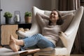Cheerful relaxed beautiful 20s girl resting in comfortable armchair