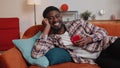 Cheerful young man lying on sofa, using mobile phone share messages on social media application Royalty Free Stock Photo