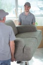 cheerful removals men carrying sofa