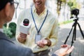 cheerful reporter holding microphone near blurred