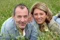 Cheerful retired couple relaxing in grass