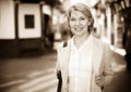 Cheerful retiree woman having a walk in city