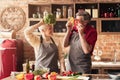 Elderly couple having fun in kitchen, playing with vegetables Royalty Free Stock Photo