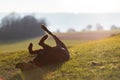 Cheerful Rottweiler somersaults in the meadow under the morning sun