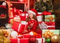 Cheerful santa helper sort presents. smiling shop assistant. kid in santa hat with many gift boxes. successful shopping Royalty Free Stock Photo