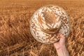 Cheerful satisfied farmer holding straw hat outdoors