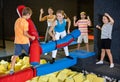 Cheerful school-age boy and teen girl friends having fun on inflatable gladiator fight arena in indoor amusement center