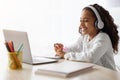 Cheerful school girl having online lesson, using laptop at home Royalty Free Stock Photo