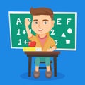 Schoolboy raising hand while sitting at the desk. Royalty Free Stock Photo