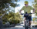 Cheerful senior active man riding at sea with his electric bicycle and yellow helmet - horizon over sea, healthy lifestyles for Royalty Free Stock Photo