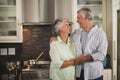 Cheerful senior couple embracing in kitchen Royalty Free Stock Photo
